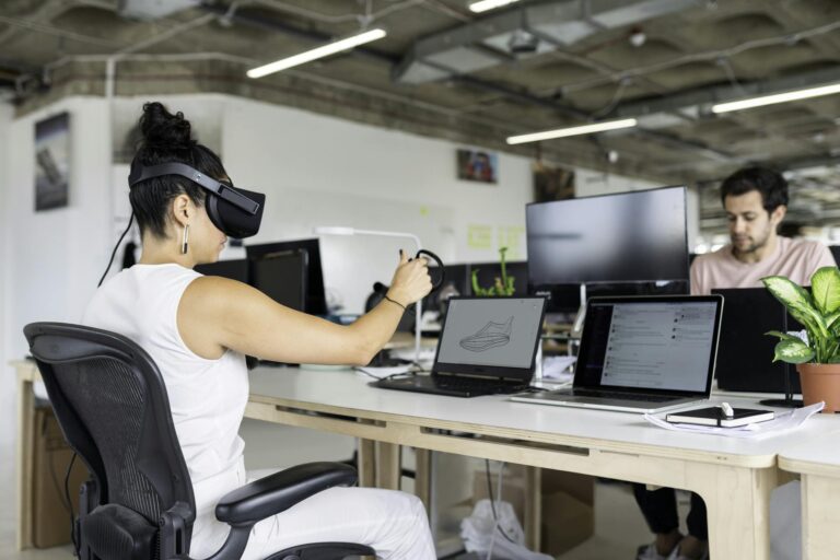 Woman using virtual reality headset in a modern office for design and innovation.